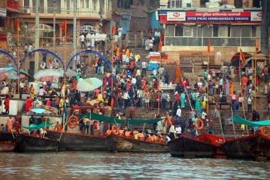 VARANASI BHOJPUR PURVANCHAL INDIA - 03 05 2023: Arati 'nin kutsal dini töreni. İnsanlar, Ganj nehrinin kıyısındaki Dashashwamedh Ghat 'ta dua ederek ve dini bir eylem izleyerek oturur.