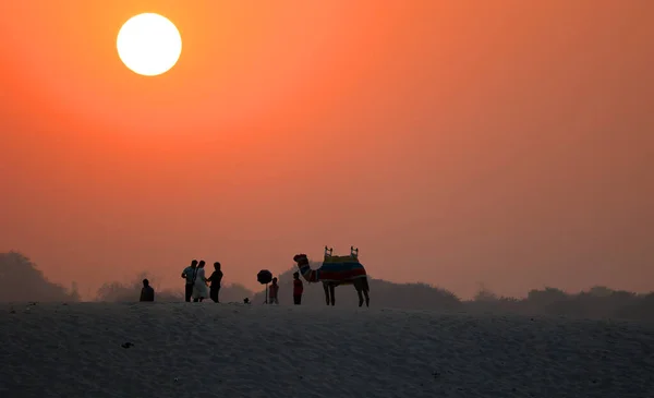 印度瓦拉纳西附近恒河东岸日出时分的人和骆驼的轮廓 — 图库照片