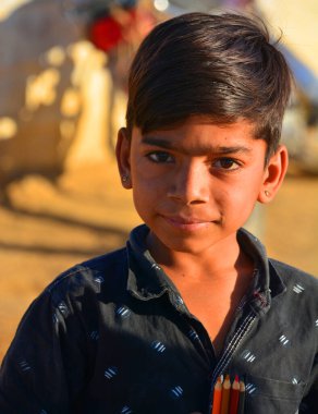 Thar Çölü 'ndeki çocuk portresi. 013.2023. (ÇN: Thar Çölündeki çocuk portresi) Çocukların evleri ve aileleriyle ilgilenmek gibi sorumlulukları var. Su alıp yiyecek için tahıl topluyorlar..