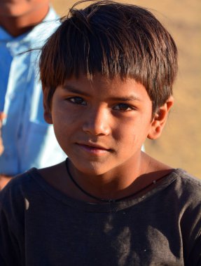 Thar Çölü 'ndeki çocuk portresi. 013.2023. (ÇN: Thar Çölündeki çocuk portresi) Çocukların evleri ve aileleriyle ilgilenmek gibi sorumlulukları var. Su alıp yiyecek için tahıl topluyorlar..