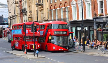 LONDRA BİRLİK KINGDOM 06 19 2023: Kırmızı çift katlı otobüs eski ve yeni versiyon yan yana. Çift katlı otobüs veya çift katlı otobüs, iki katlı veya güverteli bir otobüstür..