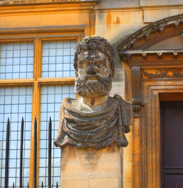 OXFORD, BİRLİK KINGDOM 06 20 2023: Sheldonian Tiyatrosu ve Bilim Tarihi Müzesi 'nin önünde genellikle İmparatorların Başları olarak bilinen sakallı adamı tasvir eden 17 taş kafa oturuyor.
