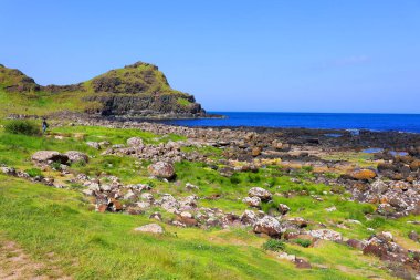 COUNTY ANTRIM 06 03 2023: Giant 's Causeway' i ziyaret eden insanlar, antik bir volkanik çatlağın sonucu olarak birbirine kenetlenmiş yaklaşık 40.000 bazalt sütunun oluşturduğu bir alandır.. 
