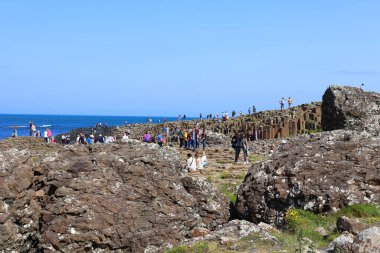 COUNTY ANTRIM 06 03 2023: Giant 's Causeway' i ziyaret eden insanlar, antik bir volkanik çatlağın sonucu olarak birbirine kenetlenmiş yaklaşık 40.000 bazalt sütunun oluşturduğu bir alandır.. 