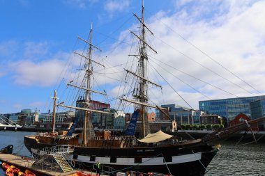 IRELAND DUBLIN REKLİK 05 28 2023: Jeanie Johnston 'da Kıtlık, Dublin' in Rıhtımlarında ve arka planda Samuel Beckett Köprüsü 'nde bulunan bir kıtlık gemisi