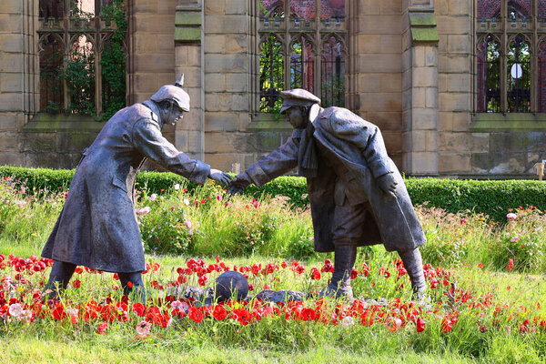 LIVERPOOL UNITED KINGDOM 06 07 2023: A sculpture commemorating the All together now statue by Andy Edwards, commemorating the Christmas Day 1914 truce, stands in grounds of St Luke's Church in Live