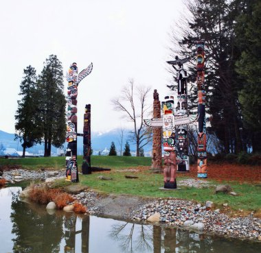 VANCOUVER BC CANADA 12. 09 2002: Stanley Park 'taki Brockton Point' teki Totem Polonyalılar en çok ziyaret edilen turistik merkezlerden biri. Oymalar Amerikan yerlilerinin bildiği hikayeleri sembolize eder.