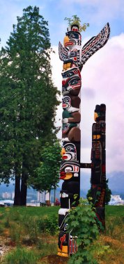 VANCOUVER BC CANADA 09 Haziran 2003: Stanley Park 'taki Brockton Point' teki Totem Polonyalılar en çok ziyaret edilen turizm merkezlerinden biri. Oymalar Amerikan yerlilerinin bildiği hikayeleri sembolize eder.