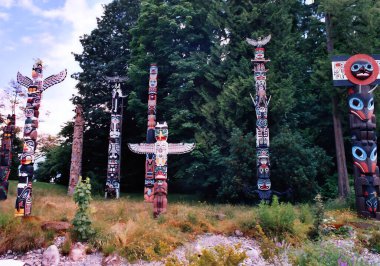 VANCOUVER BC CANADA 09 Haziran 2003: Stanley Park 'taki Brockton Point' teki Totem Polonyalılar en çok ziyaret edilen turizm merkezlerinden biri. Oymalar Amerikan yerlilerinin bildiği hikayeleri sembolize eder.