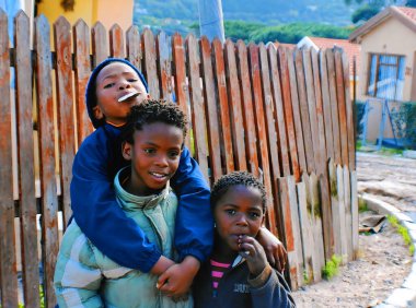 KHAYELITSHA, CAPE TOWN SOUTH AFRICA MAY 22 2007: A unidentified group of young children play on a street of Khayelitsha township in Western Cape reputed to be the largest and fastest growing in SA. clipart