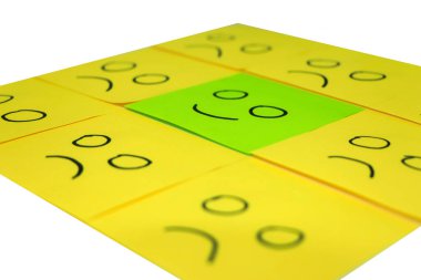 Happy concept. Background of sticky notes. Green sticky note is among yellow sticky notes.