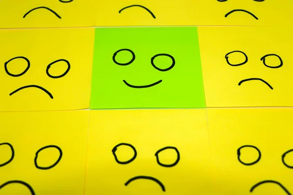 Unhappy and happy concept. Green sticky note and yellow sticky notes isolated on white background