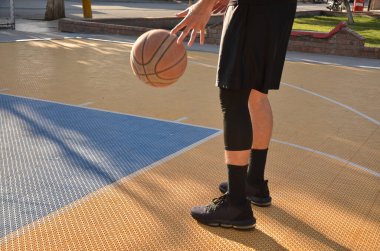 Dışarıda basketbol oynayan bir adam..