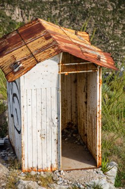 Paslı çatısı ve engebeli manzarası olan yıpranmış bir ek bina keşfetmek terk edilmişlik hissi uyandırıyor.