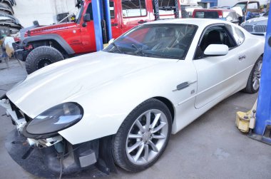 TORREON, COAHUILA, MEXICO; 30 Temmuz 2025 Lüks araç için restorasyon sürecinden geçen oto tamirhanesinde beyaz spor araba