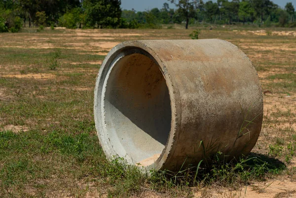 stock image Old concrete pipes lying in the autumn grass.