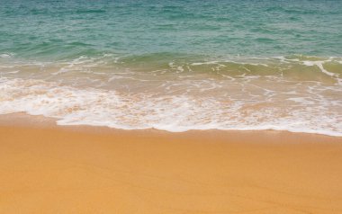 Soft beautiful ocean wave on a sandy beach. Background, summer sand beach background.