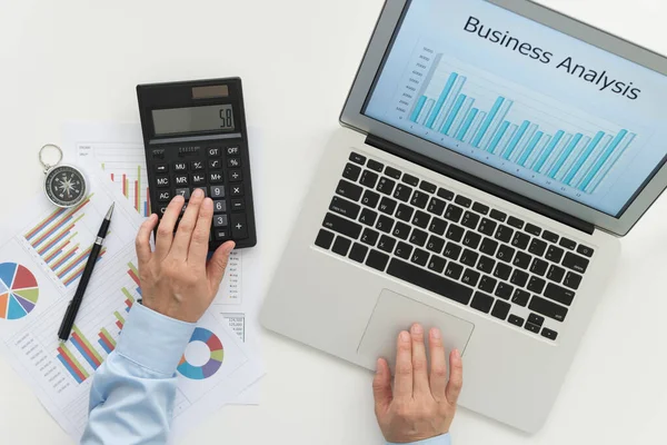 Accounting, business analysis concept. Business people using calculator and laptop computer to review performance company report. above view.