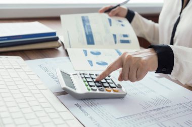 Denetim ve değerlendirme performansının rakamlarını hesaplamak için hesap makinesi kullanan iş kadınları. finans muhasebe kavramı