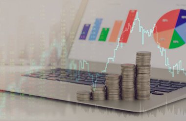 Para yığını ve yatırım portföyü dizüstü bilgisayarda indeks borsası ve grafik yükseltme grafiği ile. finans ve yatırım kavramı.
