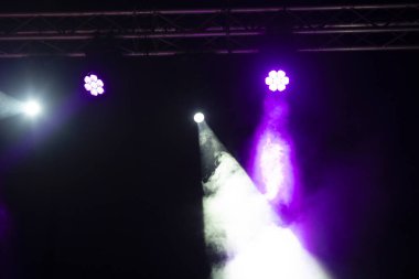 Sahne ışıklandırması. Sahnede renkli ışıkları olan spot ışıkları. Yapay ışıklandırma. Siyah arkaplan ve bulanık.