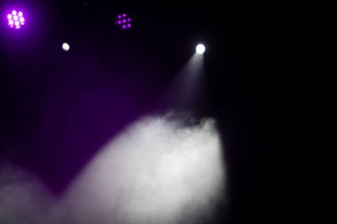 Sahne ışıklandırması. Sahnede renkli ışıkları olan spot ışıkları. Yapay ışıklandırma. Siyah arkaplan ve bulanık.