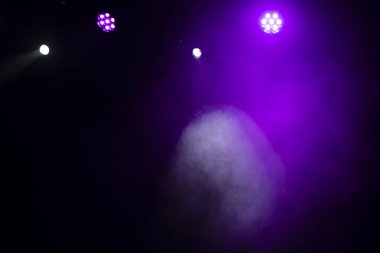 Sahne ışıklandırması. Sahnede renkli ışıkları olan spot ışıkları. Yapay ışıklandırma. Siyah arkaplan ve bulanık.