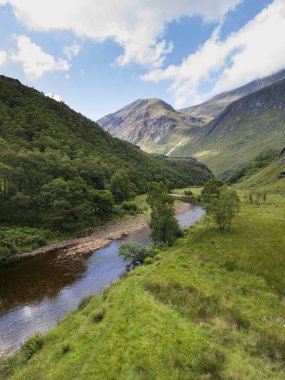 Glen Nevis 'teki Nevis Nehri' nin Suyu manzarası ve arka planda Ben Nevis dağı. İskoç dağları