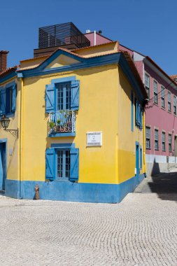 Portekiz 'deki Aveiro kanalı yakınlarında mavi pencereli sarı ev.