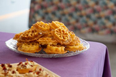 Karnaval Çiçekleri, tipik bir Galiçya tatlısıdır. Tavada kızartılmış çiçekler, temiz cam bir tabakta, bir ortanca çiçekliğinde..