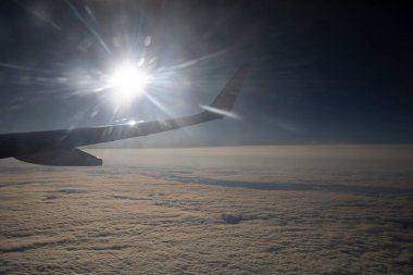 Bulutların manzarası ve pencereden bir uçak kanadı. Uçakla uçmak, uçakla seyahat etmek.