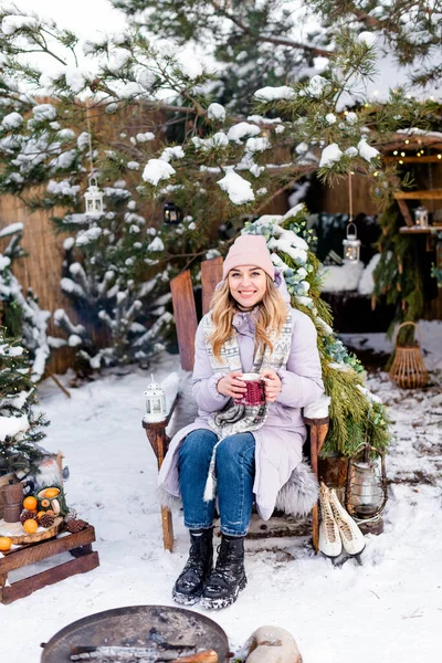 Uśmiechnięta Piękna Dziewczyna Siedzi Drewnianym Krześle Pije Zimą Herbatę Przy — Zdjęcie stockowe