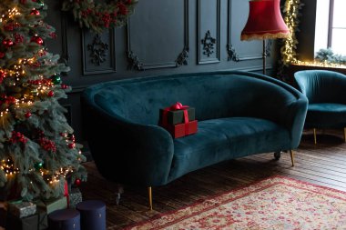 Noel arifesi. Koyu mavi kadife koltukta bir hediye kutusu.