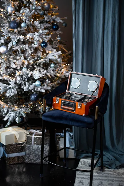 Retro compact disk digital audio on the chair near Christmas tree.