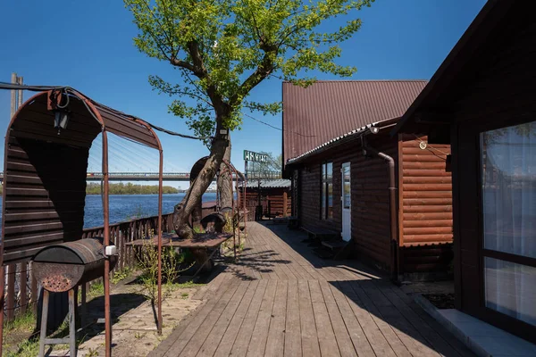 Cafe by the river - wooden terrace, barbecue grill, wooden houses for rest, nature. Country holiday