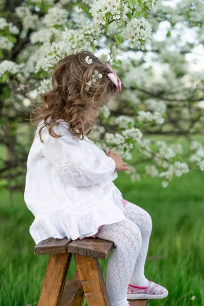 Ein Nettes Kleines Mädchen Weißem Hemd Mit Gelocktem Haar Sitzt lizenzfreie Stockbilder