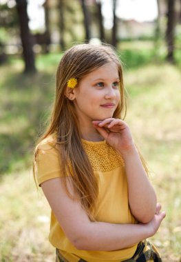 Açık havada gülümseyen genç bir kızın portresi.