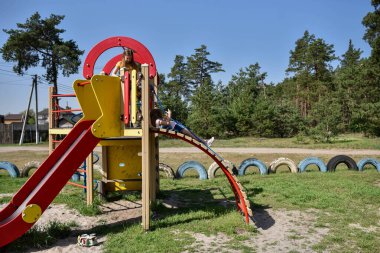 Okul çağındaki çocuklar şehir dışındaki bir çam ormanının yakınındaki parkta eğleniyorlar. Yaz tatili 