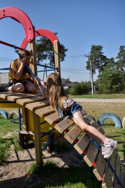 Okul çağındaki çocuklar şehir dışındaki bir çam ormanının yakınındaki parkta eğleniyorlar. Yaz tatili 