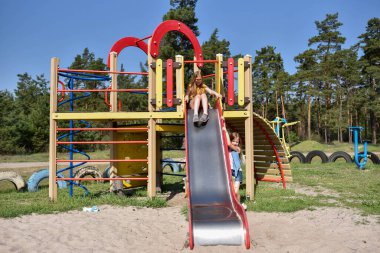 Okul çağındaki çocuklar şehir dışındaki bir çam ormanının yakınındaki parkta eğleniyorlar. Yaz tatili 