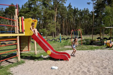 Okul çağındaki çocuklar şehir dışındaki bir çam ormanının yakınındaki parkta eğleniyorlar. Yaz tatili 