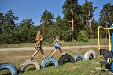 Okul çağındaki çocuklar şehir dışındaki bir çam ormanının yakınındaki bir oyun alanında oynuyorlar. Yaz tatili
