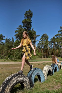 Okul çağındaki çocuklar şehir dışındaki bir çam ormanının yakınındaki bir oyun alanında oynuyorlar. Yaz tatili