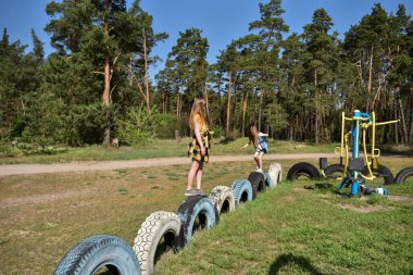 Okul çağındaki çocuklar şehir dışındaki bir çam ormanının yakınındaki bir oyun alanında oynuyorlar. Yaz tatili
