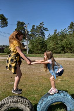 Okul çağındaki çocuklar şehir dışındaki bir çam ormanının yakınındaki bir oyun alanında oynuyorlar. Yaz tatili