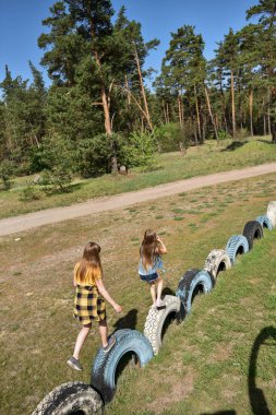 Okul çağındaki çocuklar şehir dışındaki bir çam ormanının yakınındaki bir oyun alanında oynuyorlar. Yaz tatili