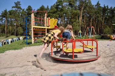 Okul çağındaki çocuklar şehir dışındaki bir çam ormanının yakınındaki bir oyun alanında oynuyorlar. Yaz tatili