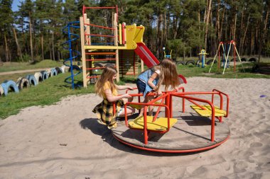 Okul çağındaki çocuklar şehir dışındaki bir çam ormanının yakınındaki bir oyun alanında oynuyorlar. Yaz tatili