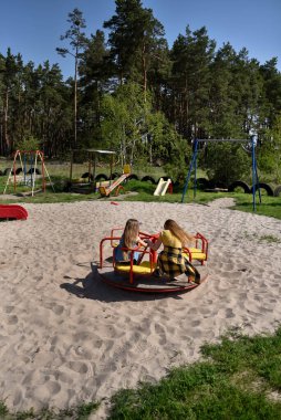 Okul çağındaki çocuklar şehir dışındaki bir çam ormanının yakınındaki bir oyun alanında oynuyorlar. Yaz tatili