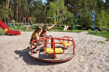 Okul çağındaki çocuklar şehir dışındaki bir çam ormanının yakınındaki bir oyun alanında oynuyorlar. Yaz tatili